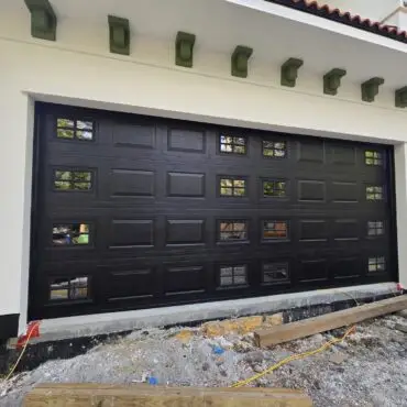 Carriage-style residential garage door with decorative hardware